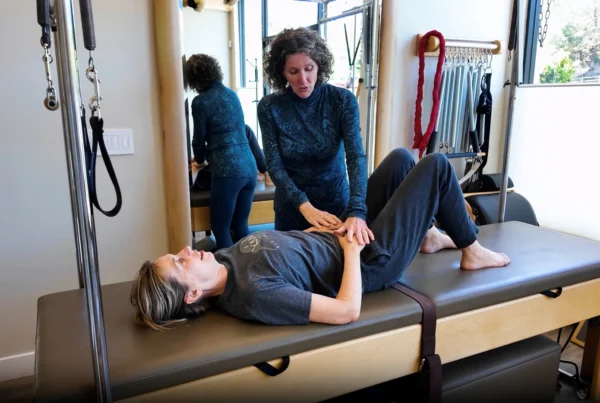 Physical therapist guiding a patient through a gentle exercise for sciatic pain relief in a San Anselmo physical therapy studio.