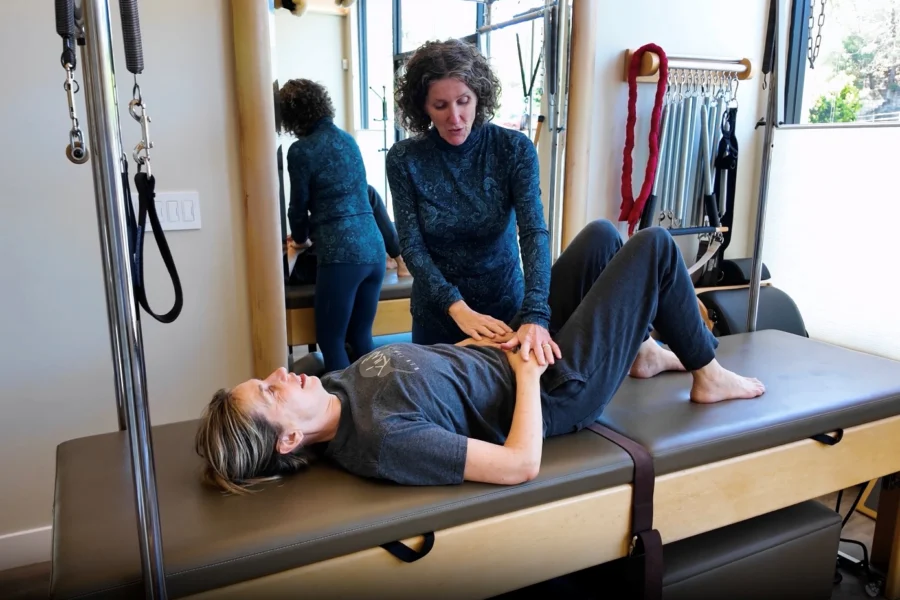 Physical therapist guiding a patient through a gentle exercise for sciatic pain relief in a San Anselmo physical therapy studio.