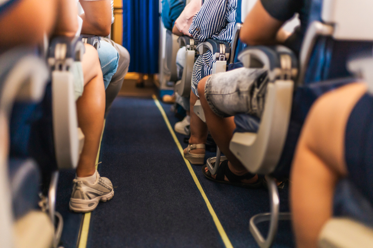 Passengers seated on an airplane during travel, illustrating prolonged sitting during flights.