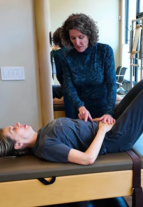 Kathleen McDonough teaching a patient proper breathing techniques to support healthy posture and movement during a physical therapy session.