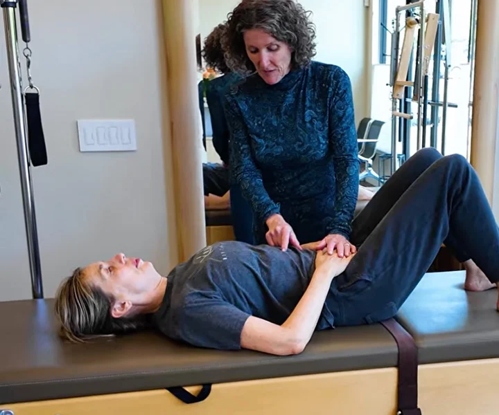 Kathleen McDonough teaching a patient proper breathing techniques to support healthy posture and movement during a physical therapy session.