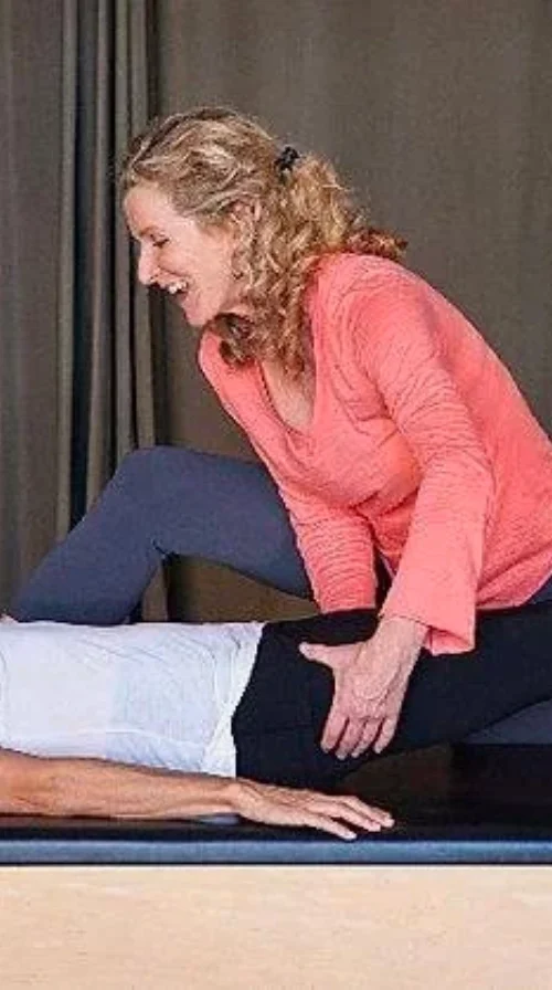 Kathleen McDonough guiding a client through a Pilates strengthening exercise
