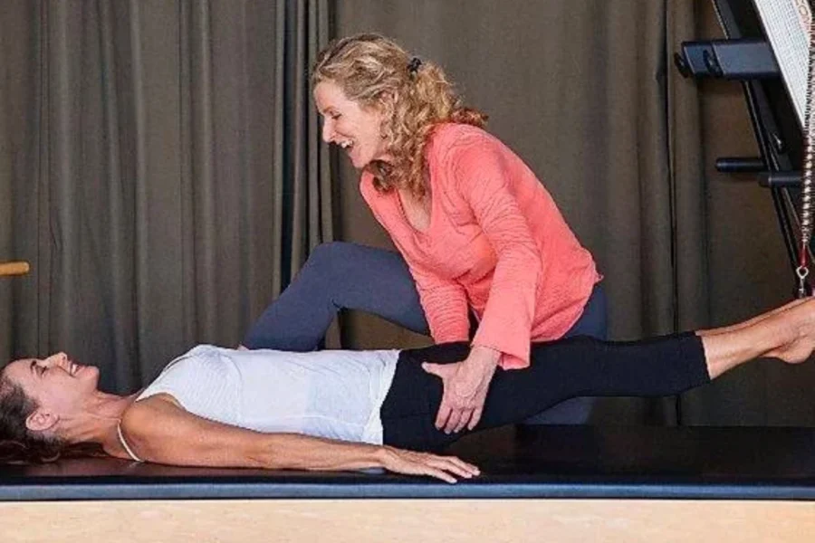 Kathleen McDonough guiding a client through a Pilates strengthening exercise