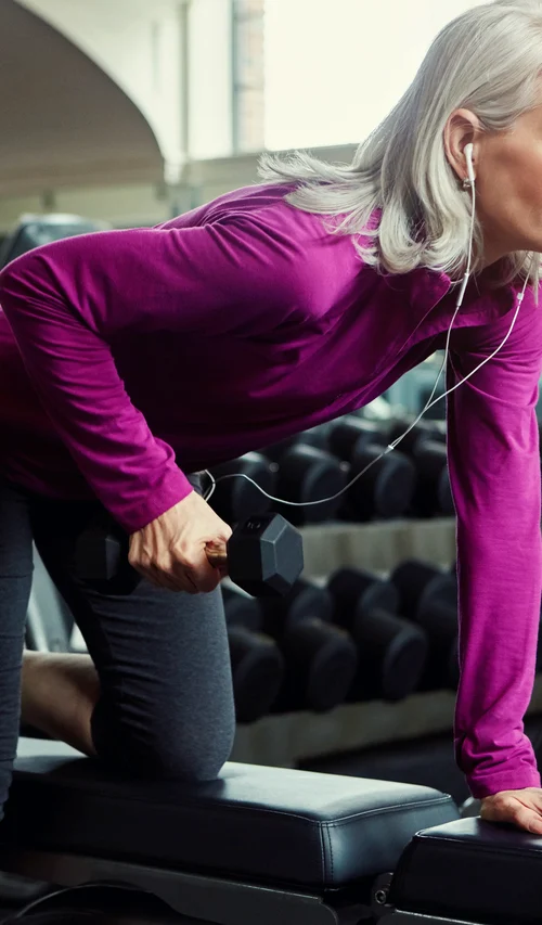 Older woman lifting a dumbbell during a strength-training workout.