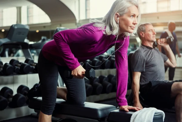 Older woman lifting a dumbbell during a strength-training workout.